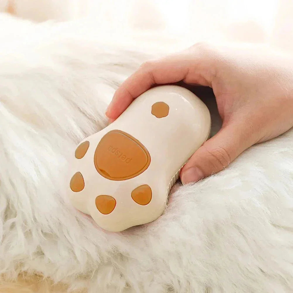 Paw-shaped pet grooming brush for cats and dogs on fluffy white fur